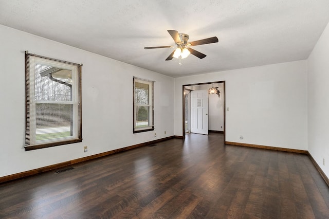 unfurnished room with visible vents, dark wood-type flooring, ceiling fan, a textured ceiling, and baseboards