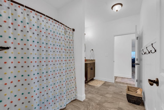 full bath with a shower with shower curtain, vanity, and baseboards