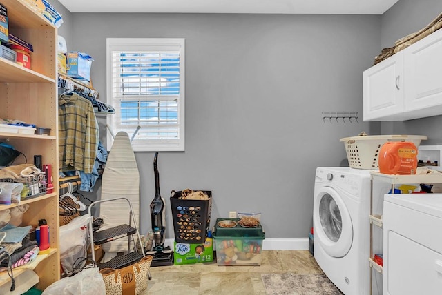 laundry room with cabinet space, baseboards, and separate washer and dryer