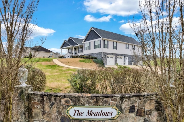 view of front of home featuring a front lawn, stone siding, and an attached garage