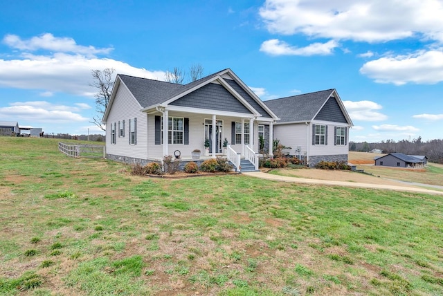 view of front of property with fence, a front lawn, and a porch