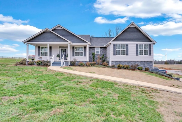 craftsman-style house with a porch, stone siding, and a front lawn