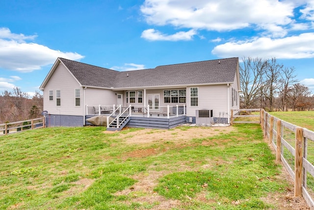 rear view of property featuring a fenced backyard, a lawn, and a wooden deck