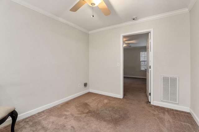 unfurnished room with baseboards, carpet flooring, visible vents, and crown molding