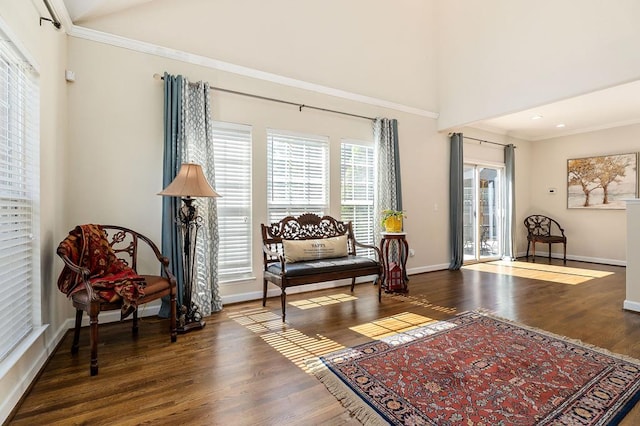 living area featuring crown molding, baseboards, and wood finished floors