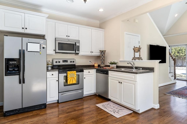 kitchen with stainless steel appliances, dark countertops, white cabinetry, a sink, and a peninsula