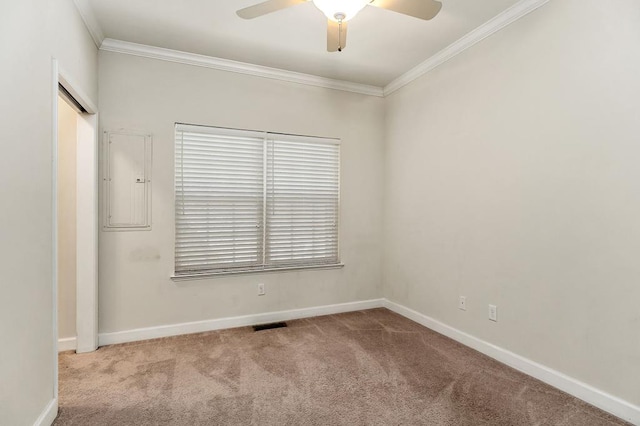 carpeted empty room with baseboards, electric panel, a ceiling fan, and crown molding