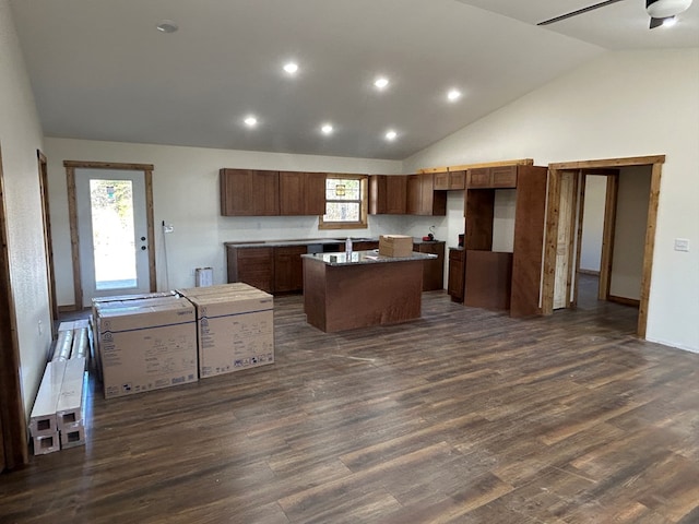 kitchen with high vaulted ceiling, dark wood-style flooring, a kitchen island, and recessed lighting