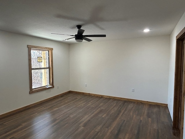 unfurnished room featuring dark wood-style floors, a textured ceiling, a ceiling fan, and baseboards