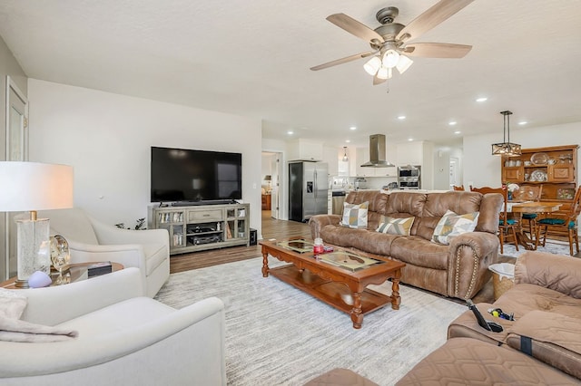 living room featuring ceiling fan, light wood finished floors, and recessed lighting