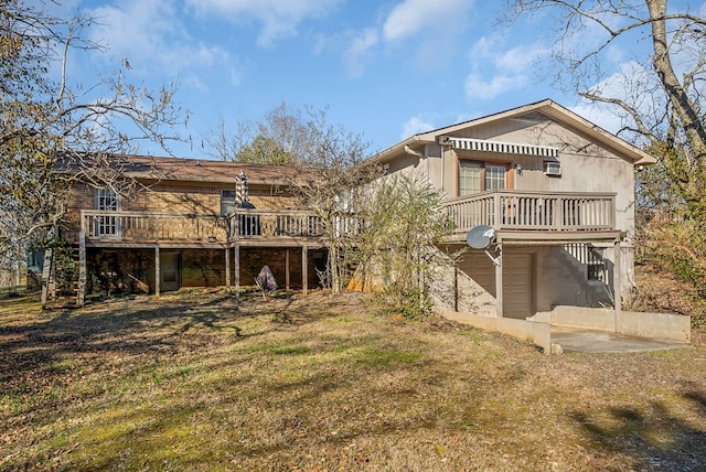 rear view of house featuring an attached garage, stairs, and a wooden deck