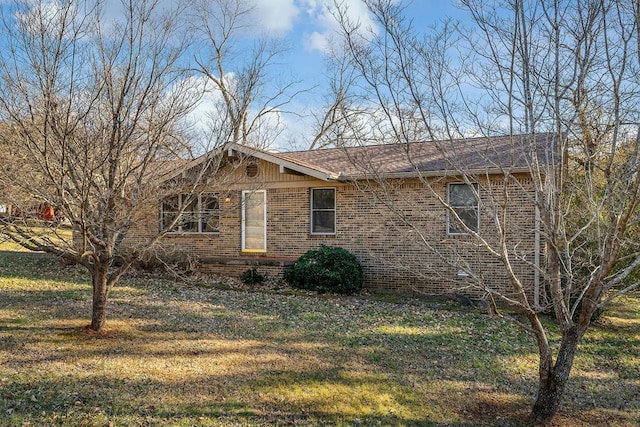 view of front of home featuring brick siding and a front yard