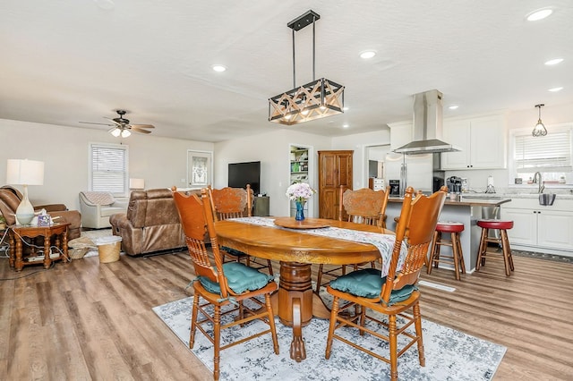 dining area with light wood-style floors, recessed lighting, and a textured ceiling