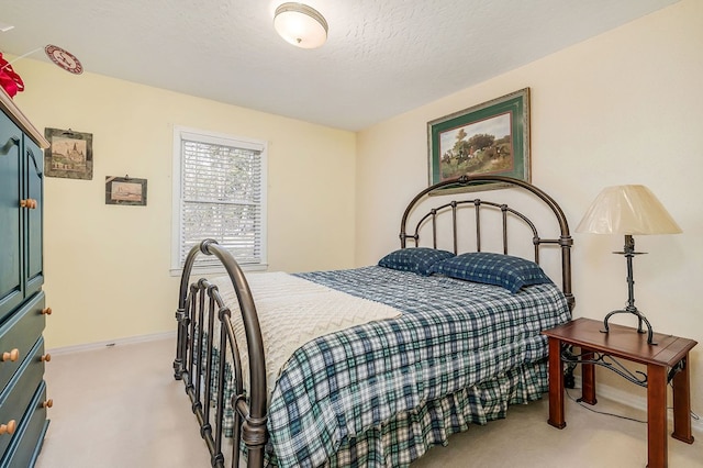 bedroom with light carpet, a textured ceiling, and baseboards