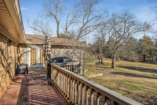 wooden deck featuring a lawn and french doors