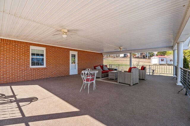 view of patio / terrace featuring ceiling fan, a storage unit, an outdoor living space, and an outbuilding