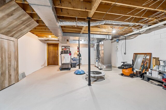 workout area with concrete block wall and heating unit