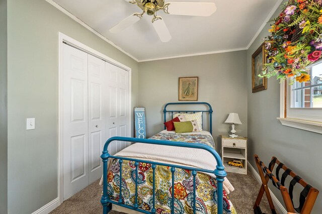 bedroom featuring a closet, carpet flooring, crown molding, and baseboards