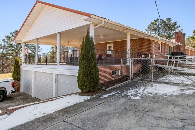 view of property exterior with a garage, a porch, and brick siding