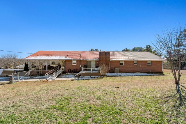 back of property featuring brick siding, a yard, a patio, metal roof, and fence