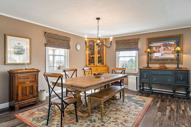 dining space with baseboards, dark wood finished floors, crown molding, and a chandelier