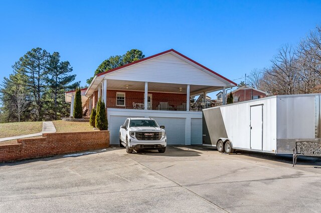 exterior space featuring driveway, an attached garage, and brick siding