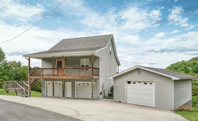 view of front facade with a garage, a shingled roof, stairs, and a porch