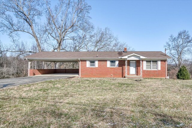 single story home featuring a carport, brick siding, driveway, and a front lawn