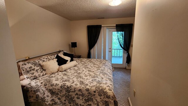 bedroom with a textured ceiling, carpet, visible vents, and access to exterior