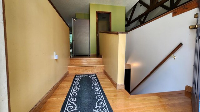 staircase with baseboards and wood finished floors