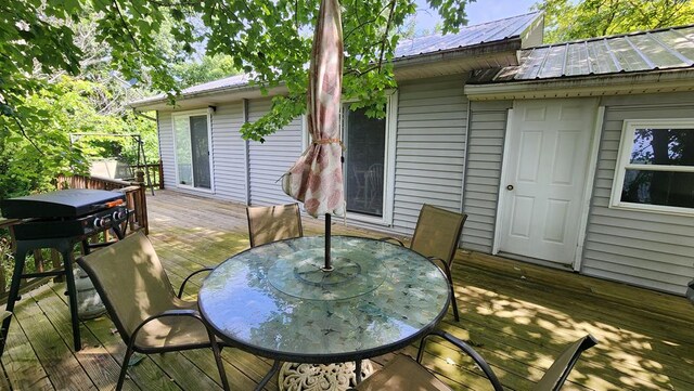 wooden terrace featuring outdoor dining area and area for grilling