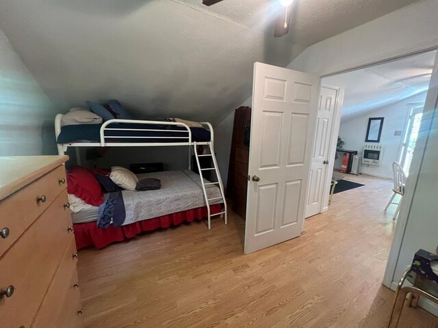 bedroom with vaulted ceiling, ceiling fan, and light wood finished floors