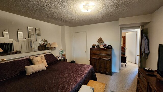 bedroom featuring a textured ceiling and light colored carpet