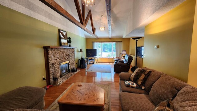 living room featuring vaulted ceiling with beams, a fireplace, and wood finished floors