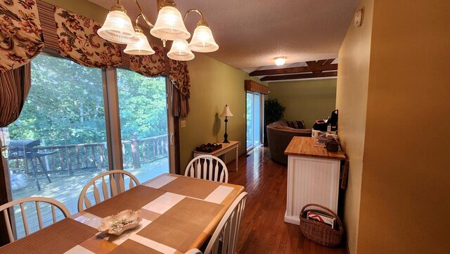 dining space featuring dark wood-style floors and an inviting chandelier