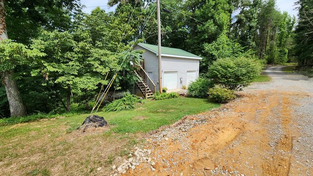 view of yard with stairs and a detached garage