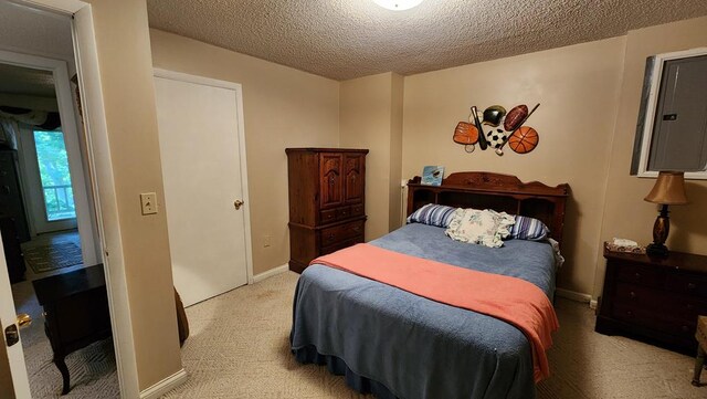 bedroom featuring light carpet, baseboards, and a textured ceiling