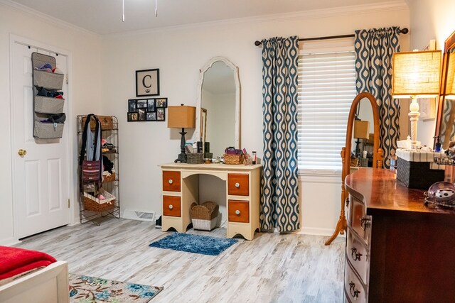 office area featuring baseboards, light wood finished floors, and crown molding