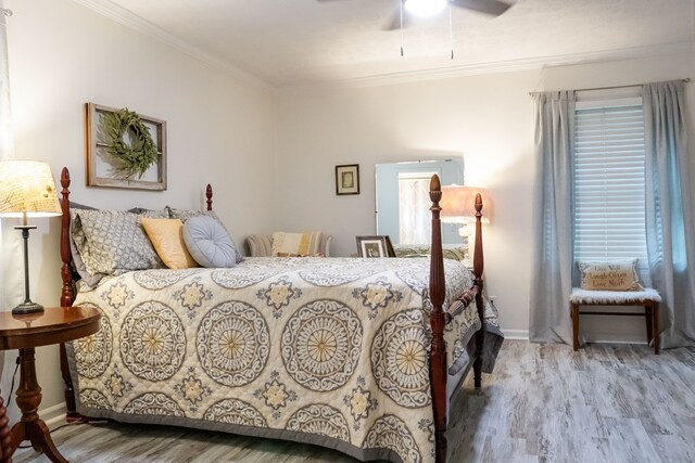 bedroom with ceiling fan, baseboards, crown molding, and wood finished floors