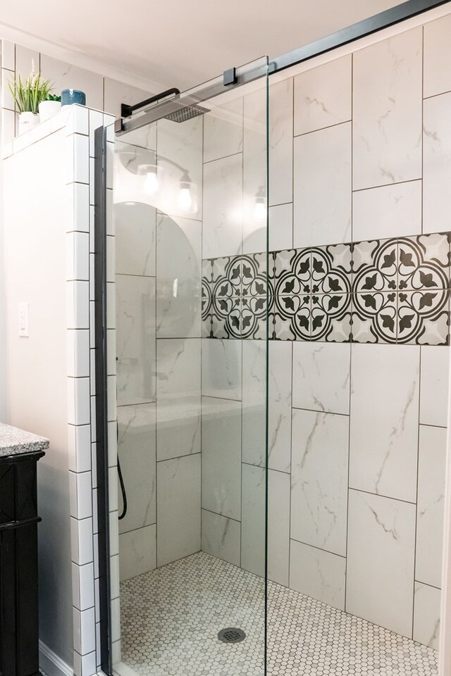 full bathroom featuring tiled shower and vanity