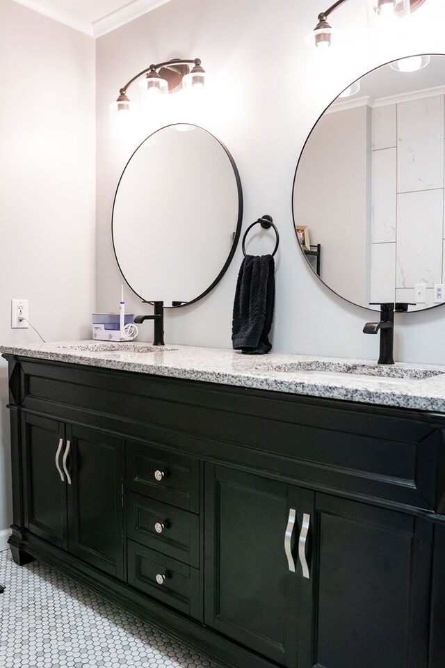 bathroom featuring double vanity, ornamental molding, and a sink