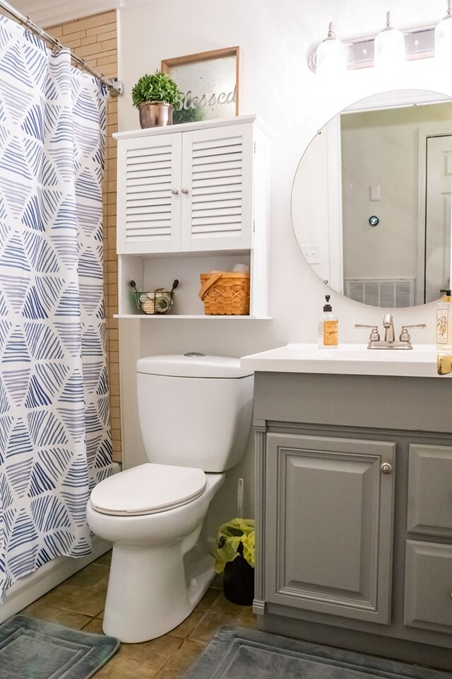 bathroom featuring toilet, curtained shower, tile patterned flooring, and vanity