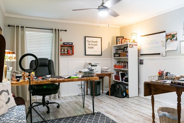 office with a wainscoted wall, light wood-style flooring, ornamental molding, and ceiling fan