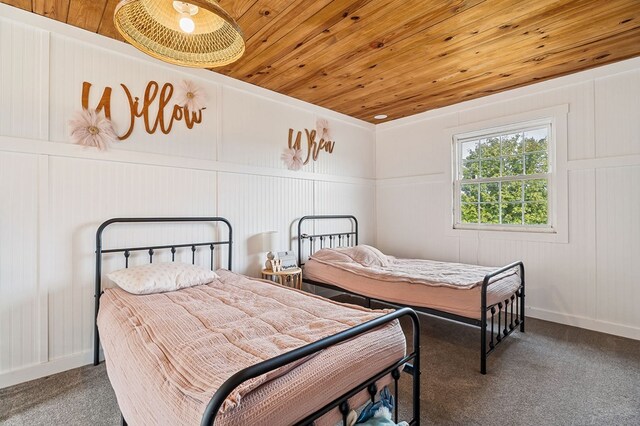 bedroom with carpet, wood ceiling, and baseboards