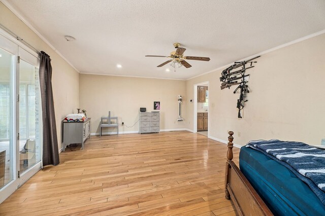 bedroom with ornamental molding, multiple windows, a textured ceiling, and light wood finished floors