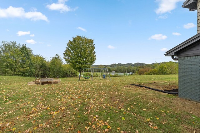 view of yard featuring a trampoline and a playground