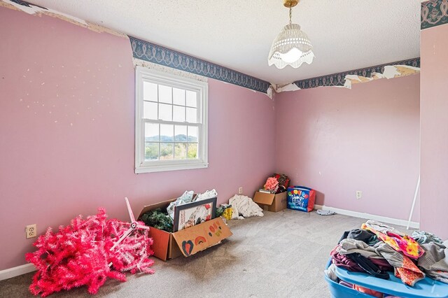 playroom featuring a textured ceiling, carpet floors, and baseboards