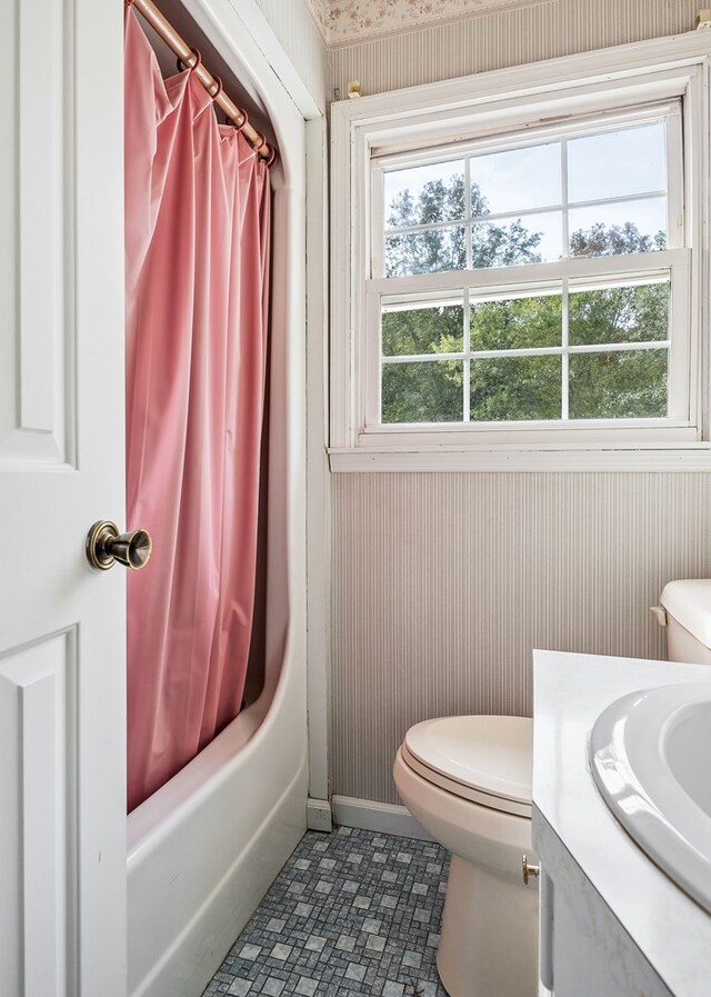 full bathroom with baseboards, shower / tub combo with curtain, vanity, and toilet