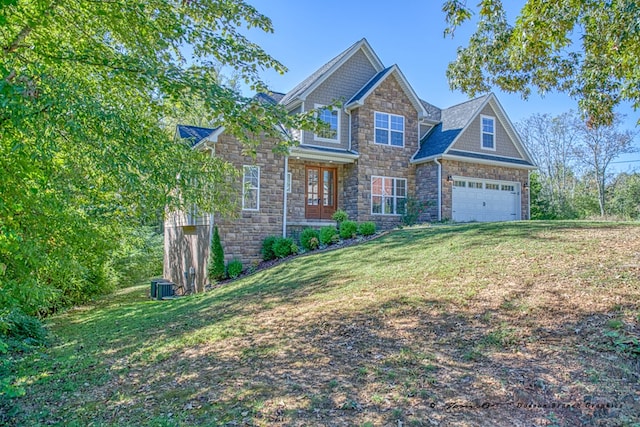 craftsman-style home with a garage, stone siding, and a front lawn