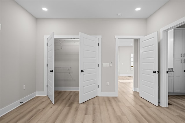 unfurnished bedroom featuring light wood-style flooring, baseboards, and recessed lighting